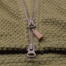 Close-up of coyote-colored hooded thermal fleece jacket zipper with textured military-style fabric detail