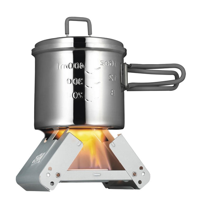 ESBIT petite cuisinière de poche pliable à combustible solide, chauffant une marmite en métal avec des marques de mesure sur une flamme de feu de camp