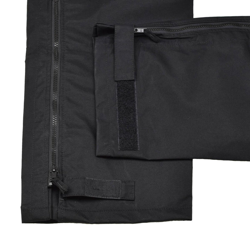Close-up of black waterproof Genuine British Metropolitan police trousers with zipper and adjustable strap details.