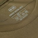 Close-up of olive M-TAC Military Tactical T-Shirt label showing size and fabric care details on breathable polyester fabric