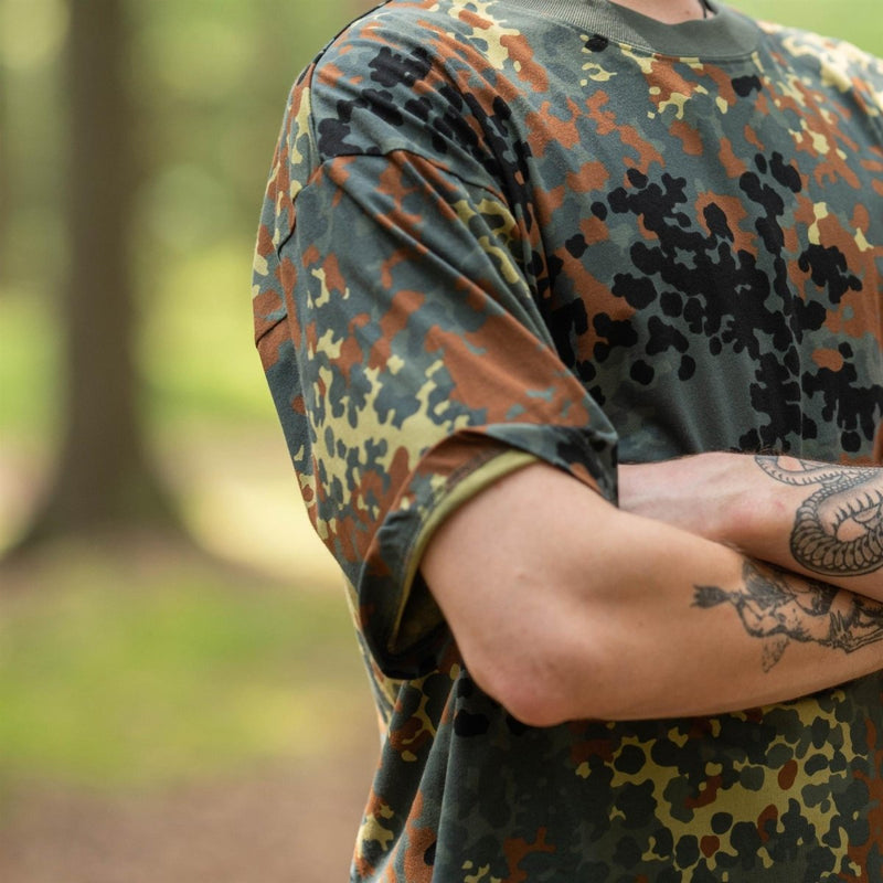 Close-up of a person wearing a lightweight breathable U.S. military-style BW camouflage flecktarn t-shirt outdoors.