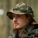 Man wearing Mil-Tec lightweight flecktarn ripstop boonie hat with adjustable chin strap in forest setting