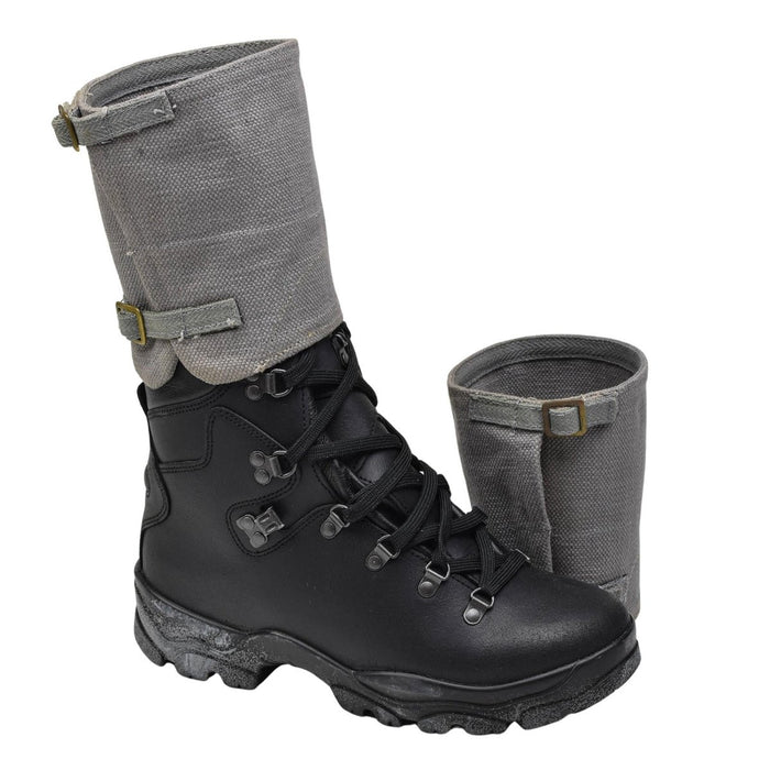 Guêtres militaires britanniques vintage originales en toile grise, présentées avec une botte de combat noire pour une protection extérieure robuste.