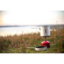 Primus Essential Trek Pot 1 liter with ceramic coating on camping stove by lakeside with frying pan nearby