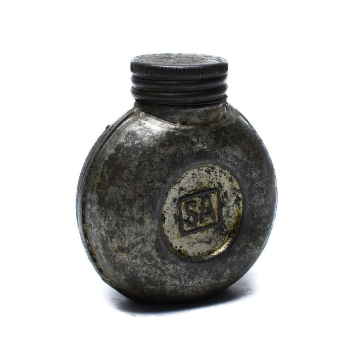 Bouteille d'encre en métal vintage avec logo « SA » sur fond blanc